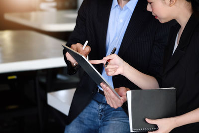 Midsection of businessman using digital tablet