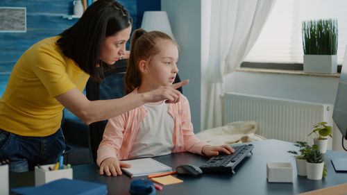 Mother assisting daughter in studies