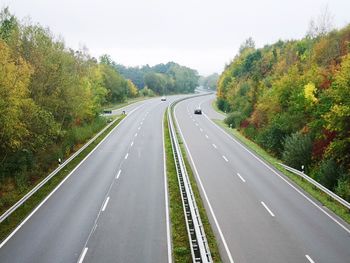 Road amidst trees against sky