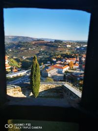 Aerial view of city against sky seen through window