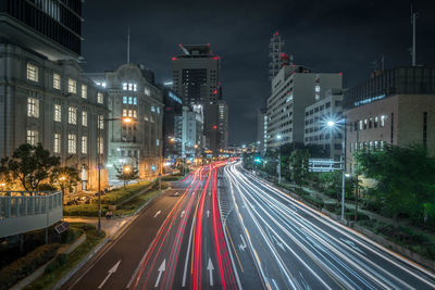 Light trails on road against sky at night