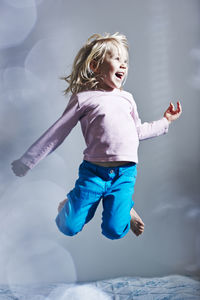 Girl jumping on bed