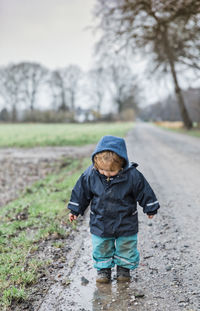 Cute boy standing on dirt road