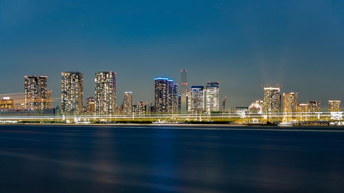 Illuminated buildings against sky at night