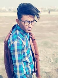 Teenage boy wearing eyeglasses while standing on field