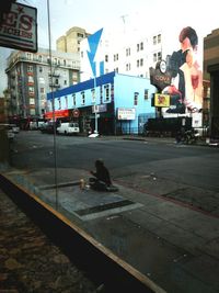 Man on road in city against sky