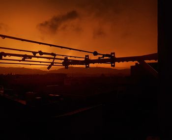 Low angle view of silhouette crane against sky during sunset