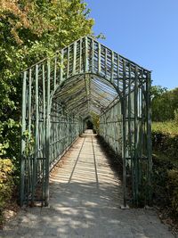 Footbridge amidst trees against sky
