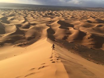 High angle view of man standing on sand dune in desert