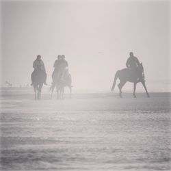 People riding horse on field during winter