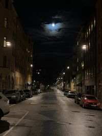 Cars on illuminated street at night