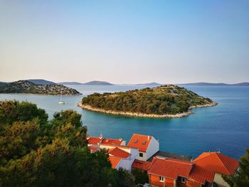 High angle view of houses by sea against clear sky
