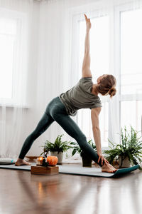 Beautiful young woman doing exercises and doing yoga at home