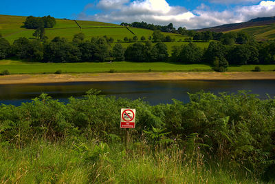 Information sign on field against sky