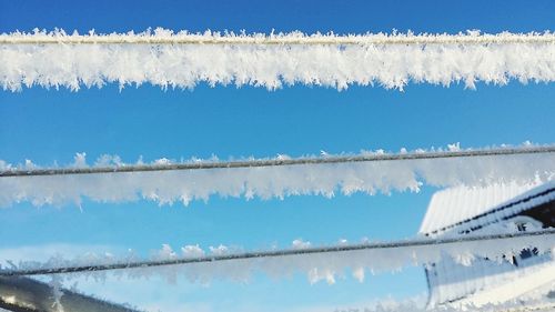 Panoramic shot of icicles against blue sky