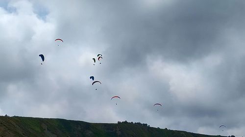 Low angle view of people flying against sky