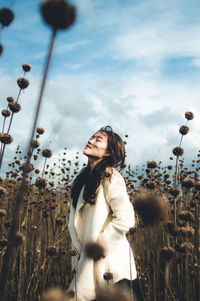 Young woman looking at camera against sky