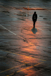 Walking shadow of an unrecognized person walking in the streets after rain