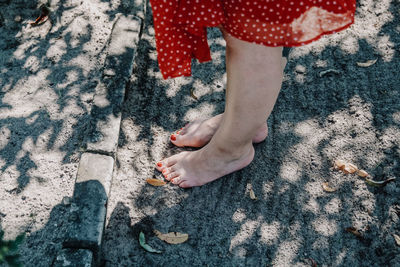 Low section of woman standing on footpath