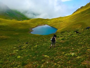 Man walking on mountain against sky