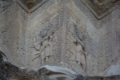 Low angle view of buddha statue against wall