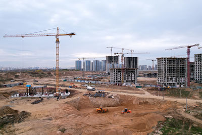 Cranes at construction site against sky