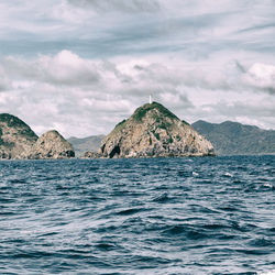 Scenic view of sea and mountains against sky