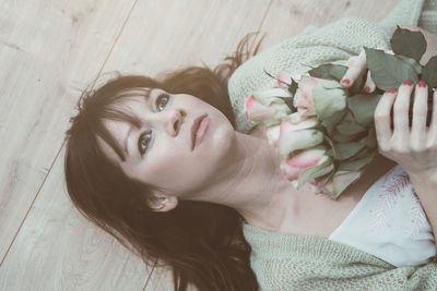 Portrait of smiling young woman relaxing on bed at home