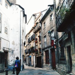 Rear view of person walking on street in city