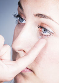 Close-up of woman applying contact lens