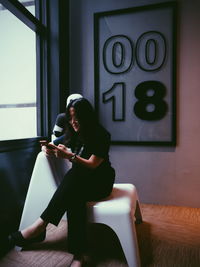 Young woman using mobile phone at home