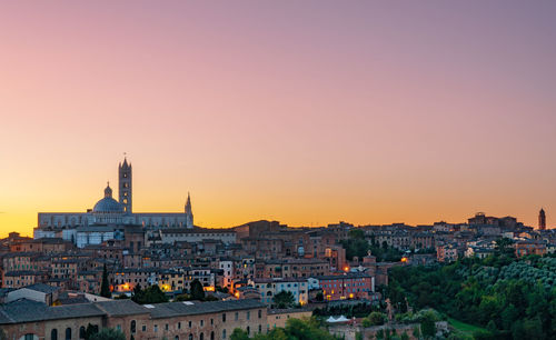 View of buildings in city at sunset