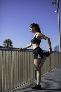 Side view of woman exercising by railing