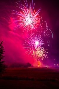 Low angle view of firework display at sunset