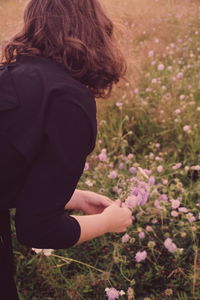 Rear view of woman picking flowers