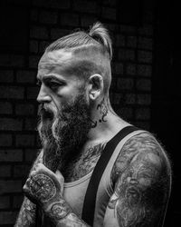 Portrait of man with beard and tattoos looking away outdoors