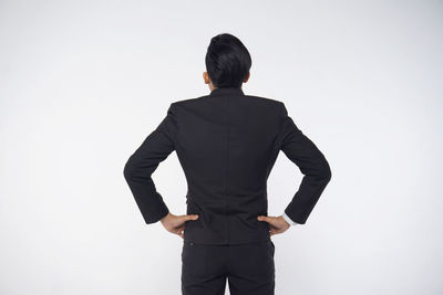 Rear view of man standing against white background