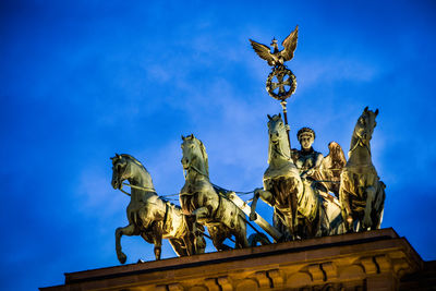 Low angle view of angel statue against blue sky