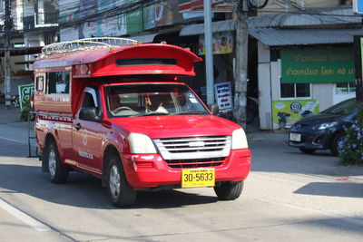 Red vintage car on road in city