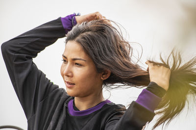 Woman grooming her long hair at remote area in thailand