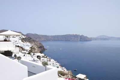 High angle view of buildings by sea against clear sky