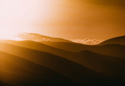 Scenic view of silhouette mountains against sky during sunset