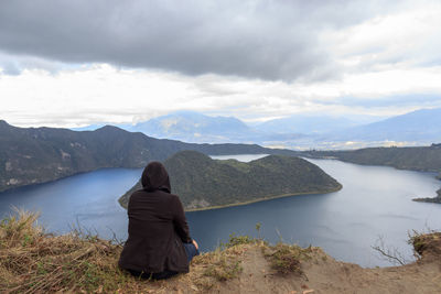 Rear view of man looking at mountains against sky