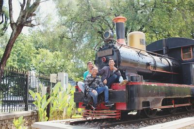Happy friends sitting on steam engine