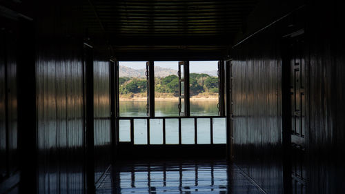 Reflection of trees on glass window in lake