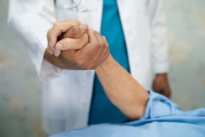 Midsection of doctor consoling patient at hospital