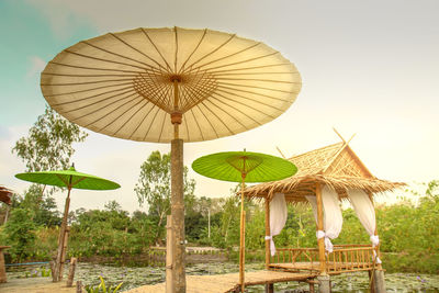 Traditional windmill on beach against sky