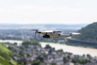 The drone hovers over the grape hills and countryside, the plastic propellers are on.