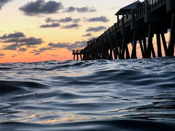 Pier over sea against sky during sunset