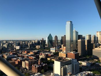 Modern buildings in city against clear blue sky